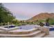 Beautiful infinity pool with mountain views surrounded by lush landscaping and tile deck at 4550 E Foothill Dr, Paradise Valley, AZ 85253