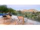 Relaxing lounge chairs overlook scenic mountain views from this elevated pool deck with glass railing at 4550 E Foothill Dr, Paradise Valley, AZ 85253
