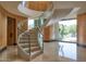 Modern spiral staircase with glass railings, wood accents, and stone floors at 4550 E Foothill Dr, Paradise Valley, AZ 85253