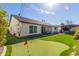 Lovely backyard features a putting green, covered patio with hot tub, and outdoor seating area at 4846 E Piccadilly Rd, Phoenix, AZ 85018
