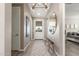 Bright hallway with wood floors, stylish light fixture, decorative mirror, and a glimpse into the bedroom at 4846 E Piccadilly Rd, Phoenix, AZ 85018