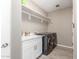 Inviting laundry room with washer and dryer, white cabinets and shelving, plus a sink at 4846 E Piccadilly Rd, Phoenix, AZ 85018