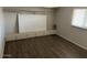 Bedroom with plank flooring, built-in cabinets, and a window offering natural light at 5201 W Camelback Rd # 181, Phoenix, AZ 85031