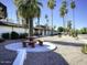 Community exterior showing the picnic area with tables and the surrounding lush landscaping at 5201 W Camelback Rd # A7, Phoenix, AZ 85031