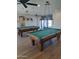Bright game room with pool tables, pendant lighting, and ceiling fans for residents at 5201 W Camelback Rd # A7, Phoenix, AZ 85031
