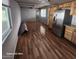 Open floor plan with wood floors, natural light, and stainless steel refrigerator in kitchen at 5201 W Camelback Rd # A7, Phoenix, AZ 85031