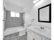 Bright bathroom with a tub-shower combo with marble-style tile and a framed mirror at 5338 N 21St Ave, Phoenix, AZ 85015