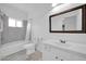 Well-lit bathroom with a tub-shower combo and a vanity with a dark wood framed mirror at 5338 N 21St Ave, Phoenix, AZ 85015