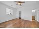 A bright bedroom features wood floors, a ceiling fan and a door to a walk-in closet at 5338 N 21St Ave, Phoenix, AZ 85015