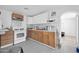 Bright kitchen featuring white appliances, wooden cabinetry, and an arched doorway at 5338 N 21St Ave, Phoenix, AZ 85015