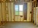 Unfinished bedroom showcasing wood framing, insulation, and a window at 5633 W Mcneil St, Laveen, AZ 85339