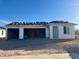 Unfinished single-story home with a three-car garage and beautiful blue sky at 5633 W Mcneil St, Laveen, AZ 85339