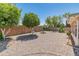 Spacious backyard featuring desert landscaping, mature trees, and a block wall for privacy at 6217 E El Paso St, Mesa, AZ 85205