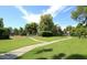 View of manicured community green space with a walking path leading to tennis courts and condo buildings at 9396 E Purdue Ave # 220, Scottsdale, AZ 85258