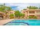 Community pool and patio area with lounge seating surrounded by mature landscaping and multi-story condos at 9396 E Purdue Ave # 220, Scottsdale, AZ 85258