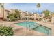 An exterior view of the community pool and hot tub area with condos and lounge chairs at 9396 E Purdue Ave # 220, Scottsdale, AZ 85258