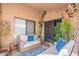 Cozy covered patio is furnished with comfortable wicker seating and colorful cushions at 11381 E Poinsettia Dr, Scottsdale, AZ 85259