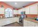 Well-lit kitchen features white cabinets, granite countertops, stainless steel appliances and a large window at 11381 E Poinsettia Dr, Scottsdale, AZ 85259