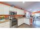 Bright kitchen boasts granite countertops, stainless steel appliances, and views into the living area at 11381 E Poinsettia Dr, Scottsdale, AZ 85259