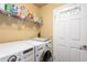 Bright laundry room includes modern washer and dryer with wire rack storage above at 11381 E Poinsettia Dr, Scottsdale, AZ 85259