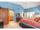Comfortable main bedroom with bathroom access, blue walls, and stylish decor at 11381 E Poinsettia Dr, Scottsdale, AZ 85259