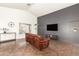 Comfortable living room with a vaulted ceiling, dark accent wall, tile flooring, and large windows at 12506 W Dreyfus Dr, El Mirage, AZ 85335