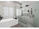 Modern bathroom with a glass-enclosed shower, soaking tub, and window shutters at 12755 N 99Th Pl, Scottsdale, AZ 85260