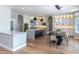 Open-concept kitchen with quartz countertops, modern lighting fixtures, island with seating, and hardwood floors at 12755 N 99Th Pl, Scottsdale, AZ 85260