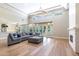 Spacious living area featuring hardwood floors, natural light, fireplace, and a comfortable grey sectional at 12755 N 99Th Pl, Scottsdale, AZ 85260