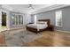 Bright bedroom with hardwood floors, a tray ceiling, and large windows at 12755 N 99Th Pl, Scottsdale, AZ 85260