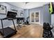 Spacious workout room featuring wood floors, treadmill, spin bike, weights, and natural light at 12755 N 99Th Pl, Scottsdale, AZ 85260
