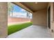 Open back patio with a concrete slab, artificial grass, and brick wall at 14140 W Georgia Dr, Surprise, AZ 85379