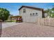 Spacious backyard featuring a stucco home, stone ground covering, and a covered patio with a wooden pergola at 14333 W Lexington Ave, Goodyear, AZ 85395