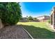 A spacious backyard featuring a well-maintained green lawn, lush trees, and sturdy block fencing for added privacy at 14333 W Lexington Ave, Goodyear, AZ 85395