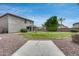 Large backyard featuring a lush lawn, mature trees, a swing set, and a spacious gravel area at 14333 W Lexington Ave, Goodyear, AZ 85395