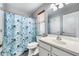 Bright bathroom features a shower-tub combo with a floral curtain at 14333 W Lexington Ave, Goodyear, AZ 85395