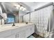 Bright bathroom featuring a double vanity and shower with curtain at 14333 W Lexington Ave, Goodyear, AZ 85395