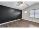 This bedroom features a modern ceiling fan and dark accent wall at 14333 W Lexington Ave, Goodyear, AZ 85395