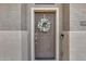 Close-up of front door showcasing a decorative wreath on a brown door, with house number to right at 14333 W Lexington Ave, Goodyear, AZ 85395