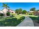 Well-manicured garden walkway lined with lush greenery, mature trees, and neatly trimmed bushes in a serene setting at 14333 W Lexington Ave, Goodyear, AZ 85395