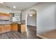 Open concept kitchen featuring stainless steel dishwasher, wooden cabinets, and a view to dining and living areas at 14333 W Lexington Ave, Goodyear, AZ 85395