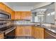 A close-up of the kitchen featuring stainless steel appliances, wooden cabinets, and a tile backsplash at 14333 W Lexington Ave, Goodyear, AZ 85395