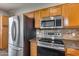 Stainless steel refrigerator and oven with microwave above, next to cabinets and tile backsplash at 14333 W Lexington Ave, Goodyear, AZ 85395