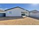 Wide view of a backyard featuring a stucco home with sliding glass doors and a block wall at 15748 W Beryl Ave, Waddell, AZ 85355