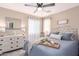 Cozy bedroom featuring a decorative mirror, a large upholstered bed, and two windows with sheer curtains at 1623 W Quick Draw Way, San Tan Valley, AZ 85144