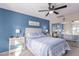 Serene bedroom with blue accent wall, soft carpet, ceiling fan, and mirrored closet doors at 1623 W Quick Draw Way, San Tan Valley, AZ 85144