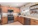 Charming kitchen features wooden cabinets, granite countertops, stainless steel appliances, and recessed lighting at 1623 W Quick Draw Way, San Tan Valley, AZ 85144
