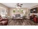 Cozy living room with a ceiling fan, wood floors, comfortable seating, and a fireplace feature at 1623 W Quick Draw Way, San Tan Valley, AZ 85144