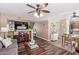 Open-concept living area with a ceiling fan, view to the kitchen, wood floors, and comfortable seating at 1623 W Quick Draw Way, San Tan Valley, AZ 85144