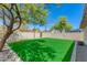 Spacious backyard features artificial turf, gravel accents and is surrounded by a block wall for privacy at 1716 N 32Nd Pl, Phoenix, AZ 85008